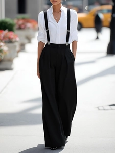 Women's black high-waisted wide-leg suspender trousers with a white long-sleeve shirt