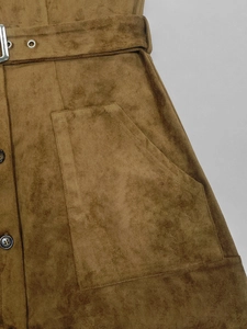 Détail de la robe en daim marron avec ceinture à œillets et grandes poches plaquées