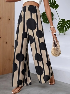 Detail showing high-waisted bohemian wide-leg pants with khaki polka dot print