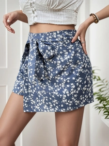 Détail du short taille haute à motif floral indigo avec nœud papillon et design portefeuille