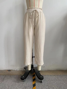 Close-up of high-waist elastic waistband with drawstring and pleated fabric texture