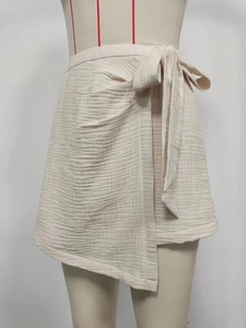 Minimalist beige wrap skirt with asymmetrical hem and side bow tie closure