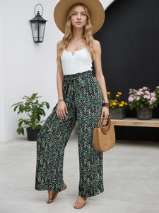 Détail d'un pantalon large à fleurs avec gilet blanc côtelé en plein air