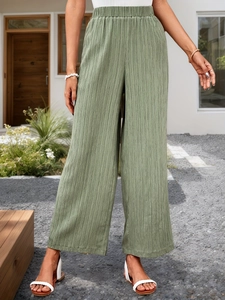 Detailed texture of sage green high-waisted wide-leg pants with elastic waist and pleats