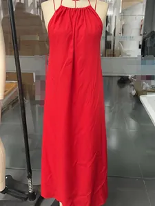Detail of red halter neck maxi dress featuring pleated neckline and flowy fabric