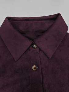 Détail de la robe en daim violet foncé montrant le col à revers et les boutons en écaille