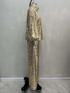 Detailed side view of golden sequin two-piece set with long sleeve top and wide pants