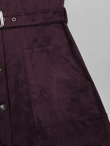 Détail d'une robe en daim bordeaux avec ceinture à boucle argentée et poche plaquée