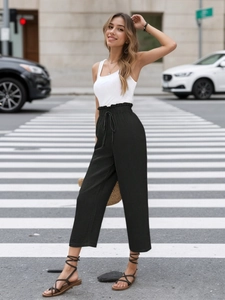 Detail of high waisted black wide leg beach trousers with elastic waist and drawstring cord