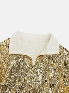 Detailed close-up of a gold sequin top collar featuring a zipper closure and beige lining