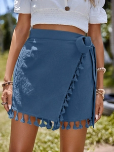 Detail of navy blue wrap skirt featuring cotton texture and bohemian tassel fringe trim