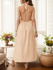 Detail view of the open-back halter neck strap and fine pleats on apricot maxi dress