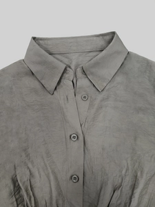 Detail of dark gray shirt dress collar with textured fabric and matching resin buttons