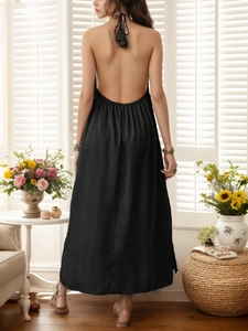 Detail of elegant black halter backless maxi dress showing sleek silk-like fabric texture