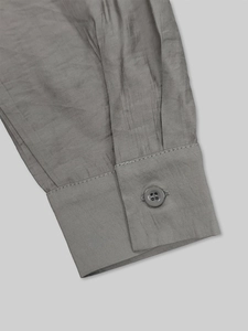 Detail of single-button cuff and woven linen-like fabric on a gray shirt dress