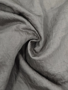 Macro shot showing the smooth texture and silky sheen of the dark charcoal shirt fabric