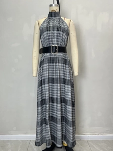 Elegante geruite maxi-jurk met halternek, brede zwarte leren riem en geplooide lange rok