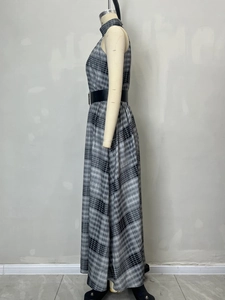 Detail van mouwloze geruite maxi-jurk met hoge taille en een zwarte brede riem