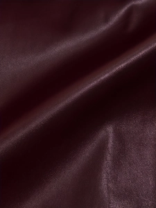 Detail shot of premium burgundy faux leather texture with soft ruched pleats and grain