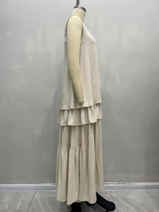 Detailansicht der gestuften Rüschen und Stofftextur am ärmellosen creme Maxi-Kleid