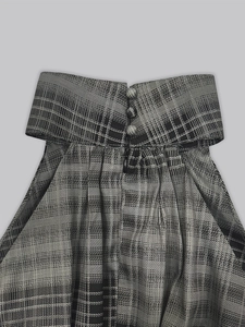 Detailopname van de taille van de grijs geruite jurk met sierknopen en onzichtbare rits
