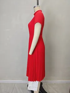 Détail d'une robe rouge plissée montrant la taille haute et les manches courtes