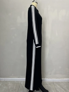 Side view of black long dress featuring sporty white stripes and knitted texture