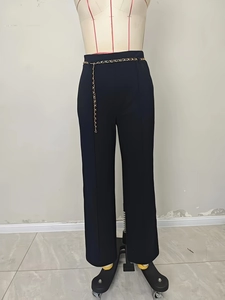 Elegant high-waisted black wide leg trousers with a decorative gold chain link belt