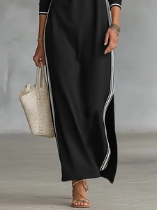 Minimalist black sweatshirt dress with white side stripes and high side slit style