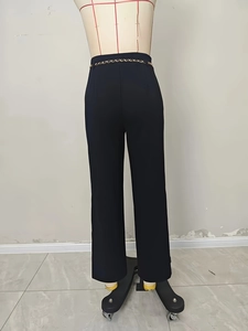 Elegant high-waisted black wide-leg suit trousers with gold chain link belt detail