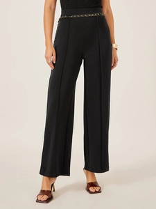 High-waisted black wide-leg suit trousers with vertical pleats and golden chain belt accessory