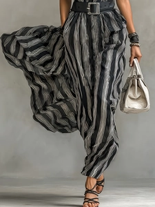 Detailed view of the black and white striped dress with a stylish wide black waist belt