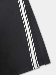 Detail showing the side slit and double white stripes on the black knit dress hem
