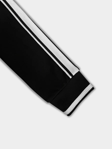 Detailed macro view of black sporty sleeve cuff with contrast white stripe piping accents