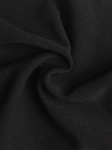 Detailed close-up showing the fine grain texture and drape of black suit pant fabric