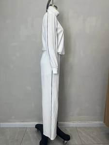Détail d'un ensemble de survêtement blanc côtelé avec bandes noires et col à demi-zip