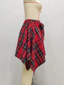 Détail de jupe asymétrique à carreaux rouges avec ceinture à nœud sur mannequin