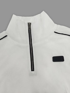 Détail d'un sweat en maille côtelée blanche à col montant zippé et finitions sportives