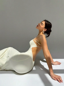 Detail of elegant white floor-length evening dress with cutout waist and open back design