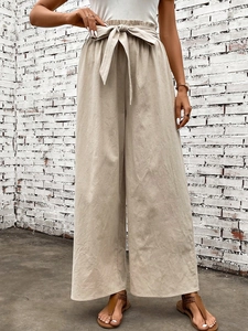 Detail view of high waist paperbag trousers with adjustable tie-knot in beige cotton