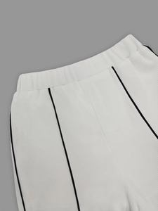Détail de la taille élastique et rayures noires sur pantalon de sport en maille côtelée