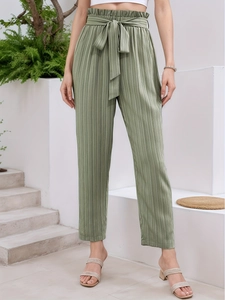 Close-up of sage green paperbag waist trousers featuring a bow tie and pleated texture