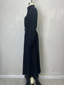 Detail view of black textured maxi shirt dress showing the waist belt and sleeve cuffs