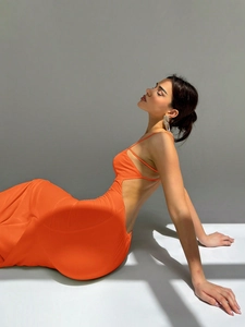 Detail of orange backless evening gown featuring elegant cut-out and silk satin texture