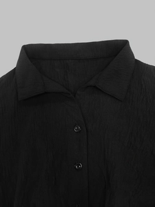 Detailed close-up of the black textured shirt collar and button down front placket