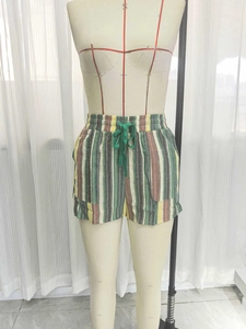 Détail d'un short de plage à rayures colorées avec cordon de serrage et poches latérales