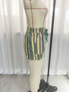 Détail de la taille élastique et du cordon de serrage vert sur le short d'été rayé