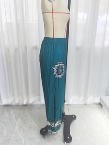 Dettaglio della stampa tribale sulle tasche dei pantaloni etnici larghi blu ciano
