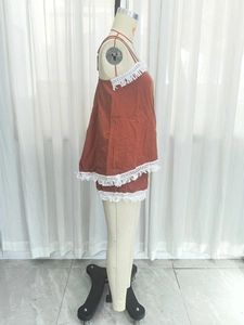 Detail of bohemian two-piece set with white fringe lace trim in rust red color