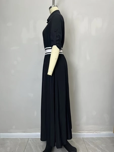 Side view of black long dress featuring lapel collar and striped waist belt detail